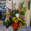 Mixed bouquet in a glass vase with lilies, roses, daisies, and chrysanthemums