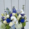 Blue and white floral arrangement with roses, orchids, lilies, and hydrangeas