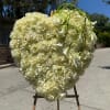 Heart-shaped white rose arrangement with calla lilies on an easel