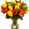 Bouquet of yellow and red roses in a clear glass vase