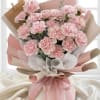 Bouquet of pale pink carnations wrapped in pink and beige paper
