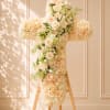 Cream floral cross on a wooden stand