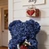 Blue teddy bear made of roses with a small gift box and Mother's Day sign