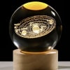 Glass orb with a glowing solar system design on a pedestal