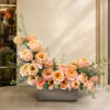 Peach roses arranged in a low rectangular vase with airy eucalyptus stems