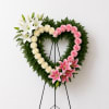 Heart-shaped floral wreath with white lilies, cream and pink roses, and pink lilies