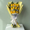 Yellow rose bouquet wrapped in pale yellow paper with a ribbon
