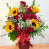 Red roses and sunflowers in a burgundy vase with a red ribbon