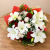 Bouquet of white lilies and red roses wrapped in red and tan paper