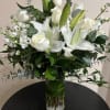 White lilies and roses arranged in a glass vase