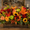 Autumn floral centerpiece with sunflowers, roses, lilies, and green apples in a wooden box