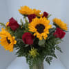 Bouquet of red roses and yellow sunflowers in a glass vase