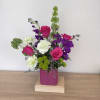 Hot pink roses and vibrant purple stock take center stage in this