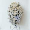White floral standing spray with a satin ribbon on an easel