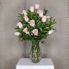 A breathtaking display of 25 soft pink roses arranged with lush greenery