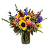 Mixed bouquet with sunflowers, roses, and blue flowers in a glass vase