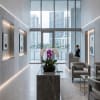 Potted white and purple orchids on a marble pedestal in a modern lobby