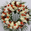 Beautiful white and orange round spray on a tall easel.
