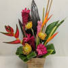 Tropical flower arrangement in a wooden container with pink, orange, and yellow blooms
