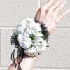 White carnation wrist corsage with black ribbon