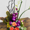 Tropical floral arrangement with purple orchids and coral roses
