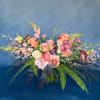 Mixed bouquet of pink and peach flowers in a glass vase