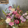 A garden-style arrangement featuring a soft mix of lavender and pink blooms