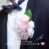 Pink and white boutonniere on a black suit jacket