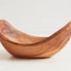 Curved wooden bowl on a plain light background