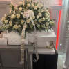 White rose funeral casket spray with lilies and ribbon on a casket