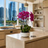 Potted magenta orchids in a white planter on a kitchen island