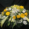 Yellow and white floral spray with lilies, roses, and daisies