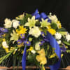 Large floral spray with white, yellow, and purple flowers and blue ribbon
