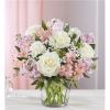 Pink and white bouquet of roses and lilies in a clear glass vase