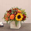 Autumn flower arrangement in a square wooden box with sunflowers and orange roses
