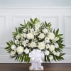 White floral standing spray with a large ribbon bow
