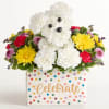 White teddy bear made of flowers in a polka-dot gift box with colorful blooms