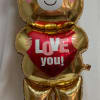 Gold teddy bear balloon holding a red heart that says "LOVE you!"