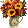 Autumn bouquet of sunflowers and chrysanthemums in a green ceramic pitcher