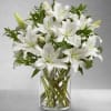 White lilies arranged in a clear glass vase