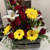 Red roses, white lilies, and yellow gerbera daisies in a wooden box