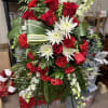 Red roses and white daisies arranged in a standing spray