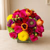 Bright mixed bouquet in a square glass vase with roses and tulips