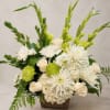 White and green floral arrangement in a brown container