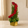 Tall red rose arrangement in a gold square vase