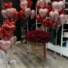 Red rose arrangement with pink and red heart balloons