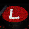 Oval box of red roses with a white rose letter L