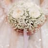 Bride holding a white rose bouquet with baby's breath