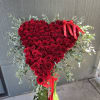 A tall floral stand beautifully arranged with lush greenery and vibrant seasonal