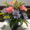 Pink and lavender flowers arranged in a dark vase